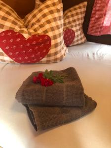 een stapel handdoeken op een bed met kussens bij Schlafen im Weinfass in Ipsheim
