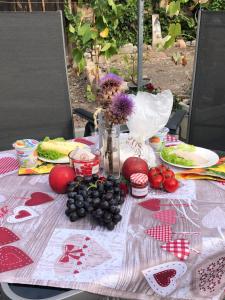 een picknicktafel met fruit en bloemen erop bij Schlafen im Weinfass in Ipsheim