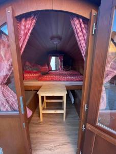een kleine kamer met een bed en een tafel bij Schlafen im Weinfass in Ipsheim