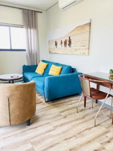a living room with a blue couch and a table at DMN City at Merensky Apartment in Windhoek