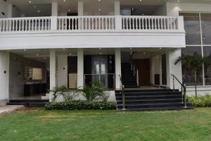 a white house with stairs and a balcony at The White Lotus in Gaya