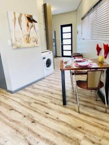 a kitchen and dining room with a table and a refrigerator at DMN City at Merensky Apartment in Windhoek