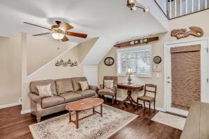 a living room with a couch and a table at Inviting waterfront cottage with balcony, firepit, marsh views, & washer/dryer in Fernandina Beach
