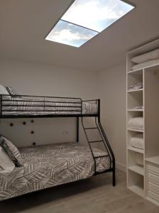 sypialnia z łóżkiem piętrowym i oknem dachowym w obiekcie Apartamento playa de Chancelas, Pontevedra w mieście Combarro