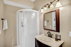 a bathroom with a sink and a shower with a mirror at Inviting waterfront cottage with balcony, firepit, marsh views, & washer/dryer in Fernandina Beach +21 photos