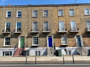 倫敦的住宿－Fab location 2 bed garden flat camden，砖砌的建筑,在建筑的一侧有五彩缤纷的门