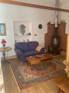 a living room with a blue couch and a fireplace at Beautiful Rural Self Contained Farm Annex in Hordle