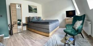 a living room with a bed and a chair at HEIMATliebe Apartment für 2 in Blankenhain