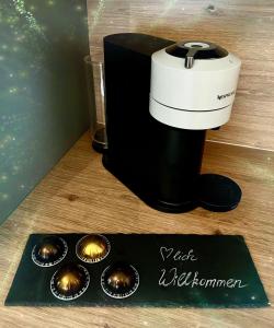 a black and white coffee maker and some cupcakes at HEIMATliebe Apartment für 2 in Blankenhain