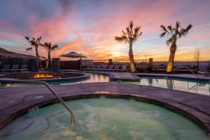 una vasca idromassaggio con palme e tramonto di Zion Village Oasis by the Pool with Lazy River a Hurricane
