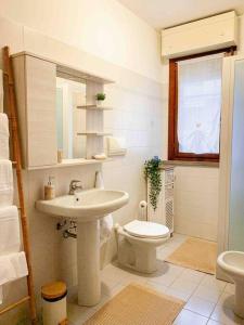 W łazience znajduje się umywalka, toaleta i lustro. w obiekcie Papini's Home: Monza w mieście Monza