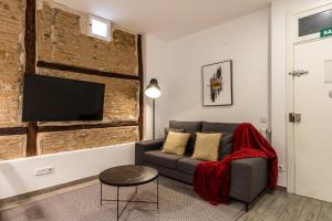 sala de estar con sofá y TV de pantalla plana en BNBHolder Relishing LA GRAN VIA, en Madrid