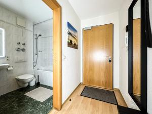 uma casa de banho com um WC e uma porta de madeira em Ambiente-Wohnung - Zentrum und Park in 5 Minuten zu Fuß - Parkplatz - Netflix em Leipzig