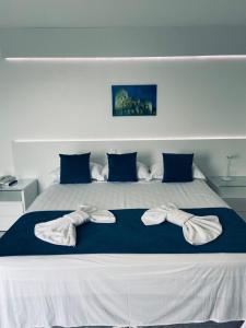 a large bed with two pairs of towels on it at Hotel Real in Cabo Frio