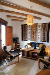 sala de estar con sofá y mesa en Casa corasol, a cozy, comfy, 2BR house- panoramic view and rooftop, en Cáñar