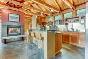 a kitchen with a bar and a fireplace at Fidalgo Island Waterfront Stunner in Anacortes