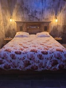 1 dormitorio con 1 cama con colcha de flores en HORIZON SPA en Samer