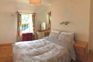 a bedroom with a bed and a dresser and a window at 3-Bedroom Cottage With Plenty Space 