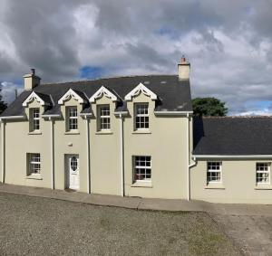 a large white house with a black roof at 3-Bedroom Cottage With Plenty Space 