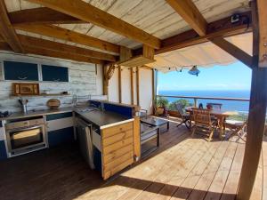 a kitchen with a view of the ocean from a deck at Le Noé in Saint-Leu