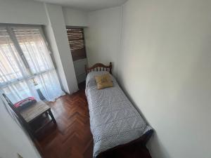 Dormitorio pequeño con cama en la esquina de una habitación en Departamento amoblado Nueva Córdoba en Córdoba