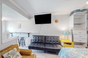 a living room with a couch and a tv on the wall at Beachview 204 in Gulf Shores