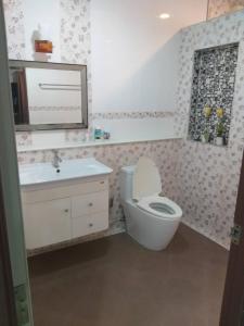 ein Badezimmer mit einem WC, einem Waschbecken und einem Spiegel in der Unterkunft การ์เด้นโฮม By คุณโทนี่ 