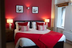 Castle Carrock的住宿－Watson Cottage, Castle Carrock, Nr Carlisle，红色卧室设有一张红色墙壁的大床