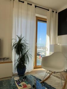 sala de estar con silla blanca y mesa de cristal en Magnifique appartement Paris, bord du canal, en Pantin