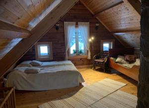 1 dormitorio en el ático con cama y ventana en 100 Years Old Norwegian Log House in Tromsø, en Tromsø