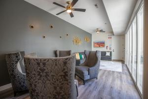 a living room with two chairs and a ceiling fan at Paramount Luxury Villa with Swim Spa Sleeps 39 in Hurricane