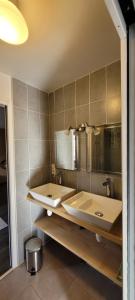 a bathroom with two sinks and a mirror at Au Clos du Célé in Bagnac