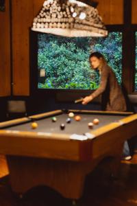 a woman standing in front of a pool table at Trogon Lodge in San Gerardo de Dota