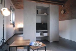 a living room with a table and a tv at Suite Factory : gîte de charme en Avesnois in Wargnies-le-Petit