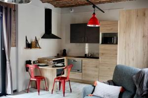 a kitchen with a table and red chairs in a room at Suite Factory : gîte de charme en Avesnois in Wargnies-le-Petit