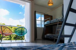Schlafzimmer mit Etagenbett und Balkon in der Unterkunft Hostal Cuca Macuca in Puerto Morelos