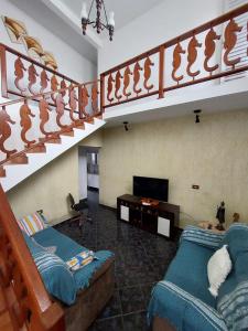a living room with two couches and a staircase at Casa com piscina aconchegante e relaxante in Mongaguá