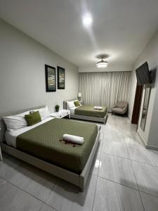 Habitación de hotel con 2 camas y sofá en Hotel Monarca, en Higüey