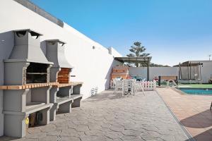 a patio with a grill and a table and a pool at VILLA CARLA FUN FAMILY in Playa Blanca