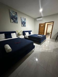 a bedroom with two beds and a living room at Hotel Monarca in Higuey