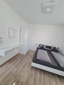 een witte slaapkamer met een bed en een witte muur bij Ganze Wohnung TOP Lage in Kempten (Allgäu) in Kempten