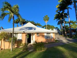 a house with palm trees in front of a street at Villa Cézanne in Sainte-Rose