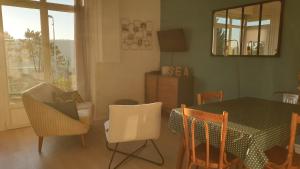 a living room with a dining room table and chairs at Rez de jardin vue mer Costa Bella in Criel-sur-Mer