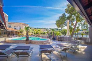 a patio with chairs and a swimming pool at Hotel Lumbarda in Lumbarda