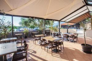 an outdoor patio with tables and chairs and windows at Hotel Lumbarda in Lumbarda