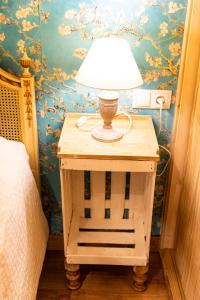 una lámpara en una mesita de noche junto a una cama en Finca MOLINO DE JARANDA - Oropéndolas, en Collado