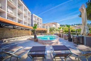 a hotel patio with chairs and a swimming pool at Hotel Lumbarda in Lumbarda