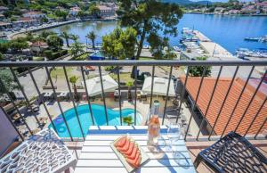 a balcony with a table and a view of a pool at Hotel Lumbarda in Lumbarda