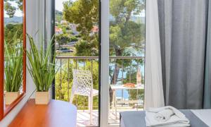 a room with a bed and a balcony with a view at Hotel Lumbarda in Lumbarda