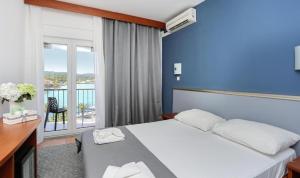 a hotel room with a bed and a balcony at Hotel Lumbarda in Lumbarda